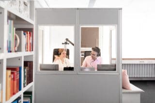 Ein Mann und eine Frau in einer Dolmetschkabine