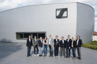 Gruppenfoto des Führungsteams der Sennheiser-Gruppe vor Firmengebäude
