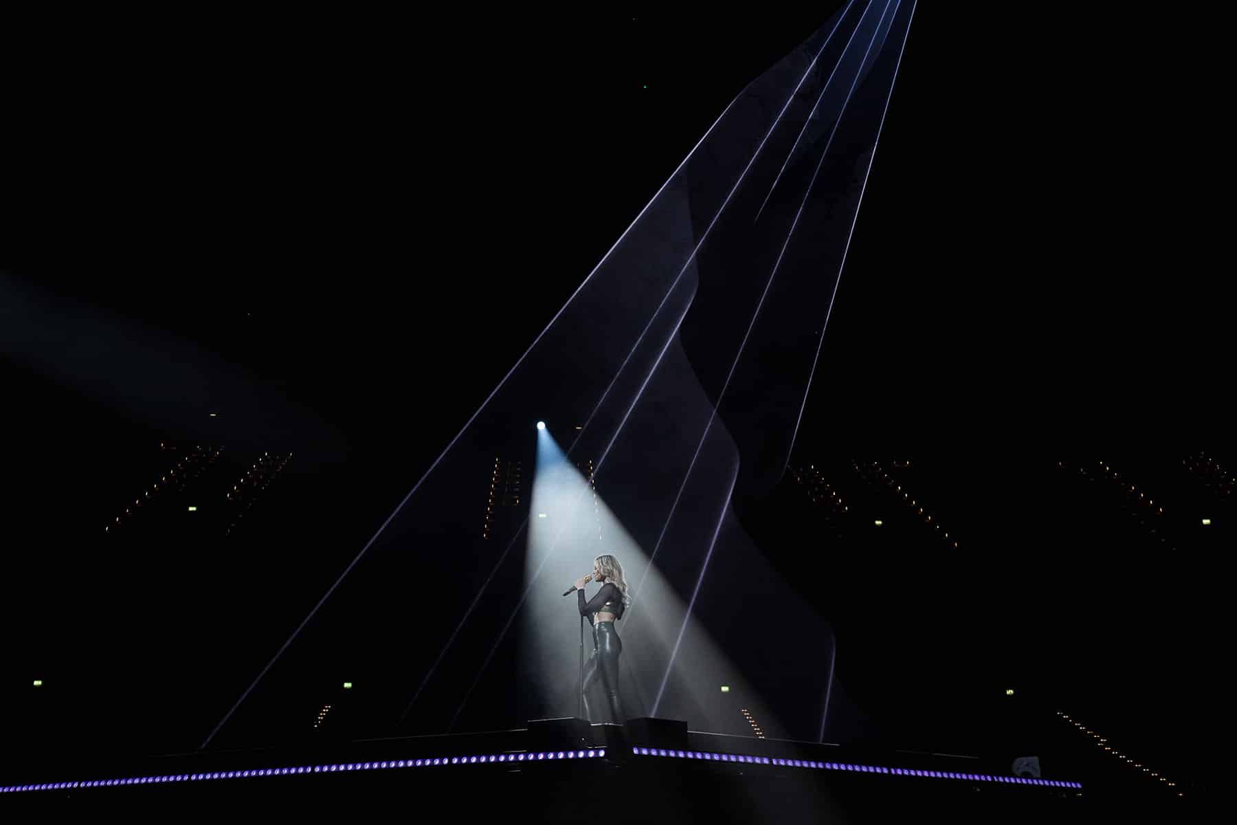 Helene Fischer allein auf der Bühne, beleuchtet von einem Spot-Scheinwerfer 