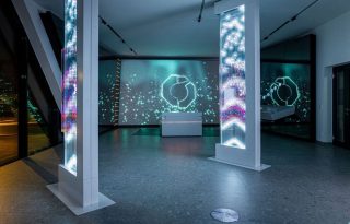 drei freistehende, deckenhohe Displays mit jeweils drei Display-Schichten