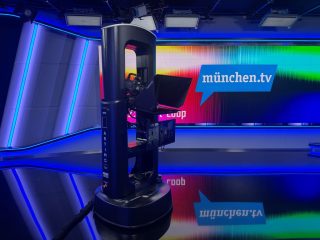 Roboter Artimo im TV-Studio von muenchen.tv, das in verschiedenen Blautönen gestaltet ist