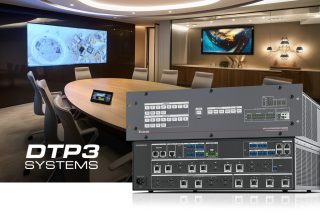 Im VOrdergrund Extron Matrix Switcher,vor einer Brüp-Szenerie mit hellbraunem Tisch und großem Bildschirm an der Wand