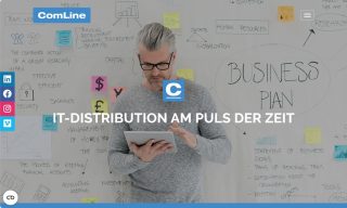 Grauhaariger Mann in grauem Pulli vor bekritzeltem Whiteboard mit Tablet in der Hand