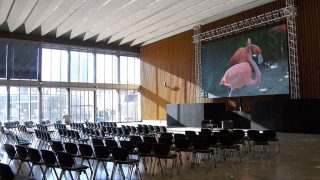 Saal mit Stühlen und LED-Wand