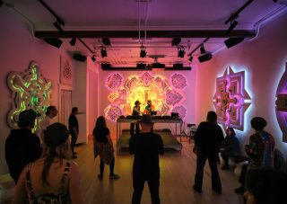 Eine Handvoll Menschen vor dem DJ-Pult