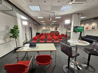 Sutioraum mit Tisch für Speaker und roten Stühlen