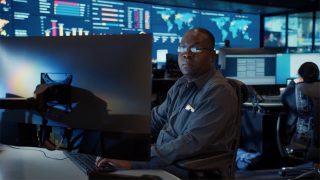 Mann in Security Operation Center am Rechner