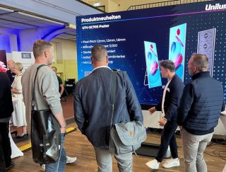 Mehrere Männer vor einem Stand von Unilumin
