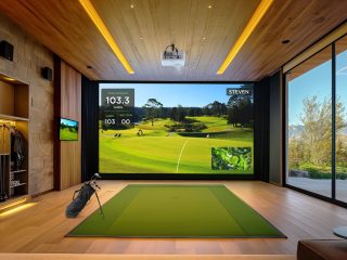 Anlage für Golf-Simulation mit Projektor an der Decke und Display an der Wand mit Golfplatzmotiv