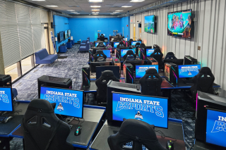 E-Sport-Labor der Indiana State University mit Reihen von Gaming-PCs, Monitoren mit „Indiana State Esports“-Logo, Gaming-Stühlen und wandmontierten Displays