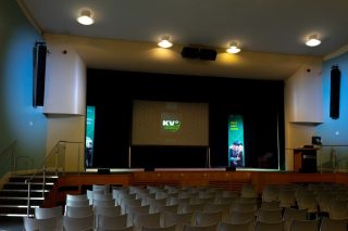 Blick in die Great Hall der University of Bradford mit geflogenen KV2-Audio-Lautsprechern links und rechts der Bühne